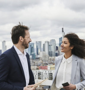 Two people talking atop a rooftop