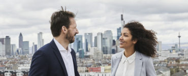 Two people talking atop a rooftop